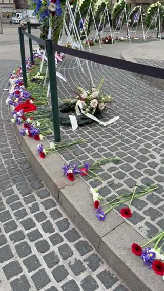 Flowers are laid on the ground as a memorial
